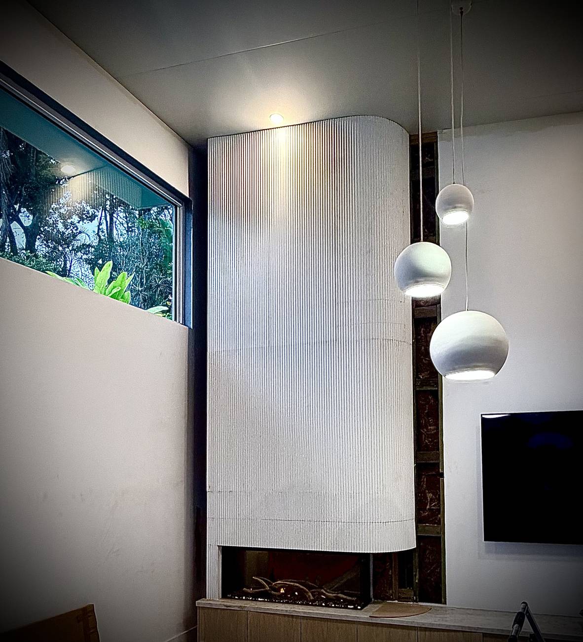 Finished curved white fluted wall over a three-sided fireplace