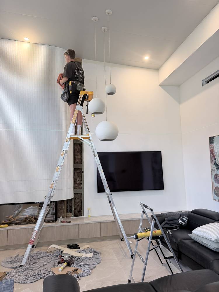 Fluted panels being fixed to the curved wall, set out to a laser line